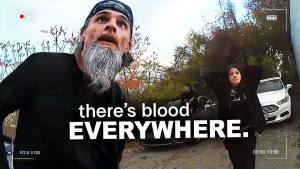 A tense moment captured as a man with a shocked expression and a woman with hands on her head react to police discovering their murder house, surrounded by cars and trees.