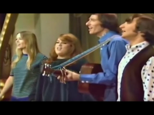 The Mamas and the Papas performing 'California Dreamin'' live on stage, featuring vibrant harmonies and acoustic guitar.