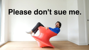 A man joyfully sitting on a bright red 3D-printed chair with text reading 'Please don’t sue me,' showcasing his innovative DIY creation.